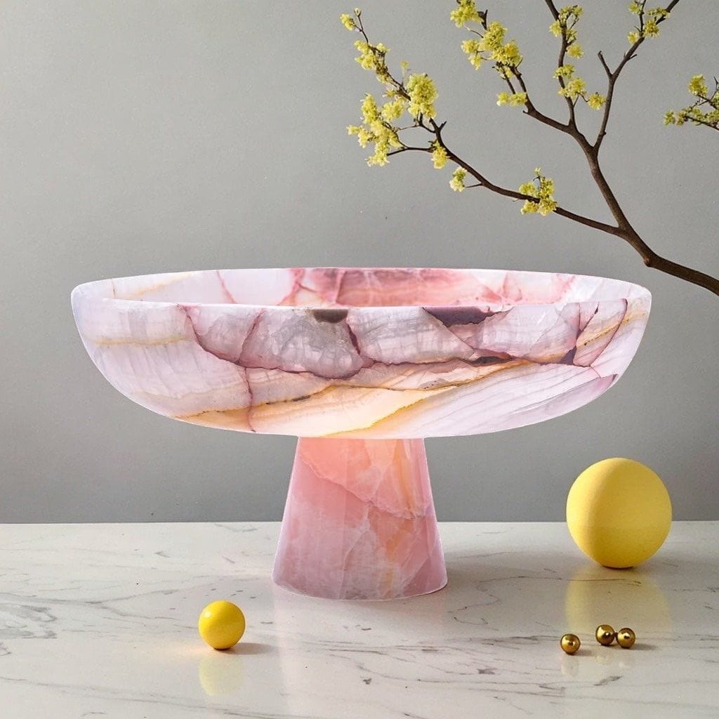 Pink onyx-effect pedestal bowl on a marble table