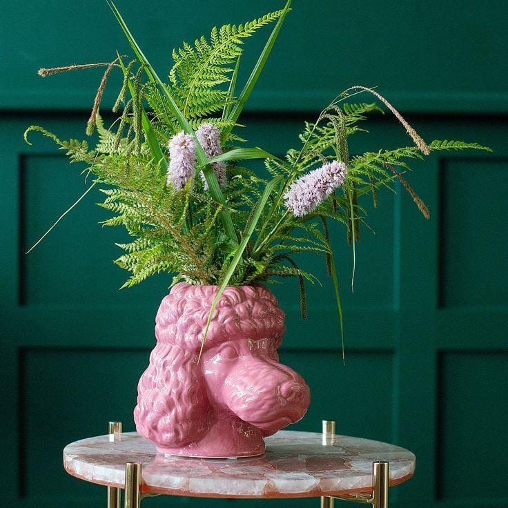 Pink ceramic poodle head vase holding ferns